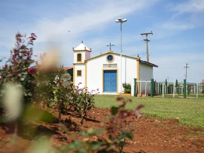 A Capela Santa Rita, branca, com o campanário e a porta azul