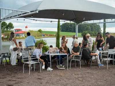 Mesas ocupadas sob as coberturas brancas do Garden, à beira do lago